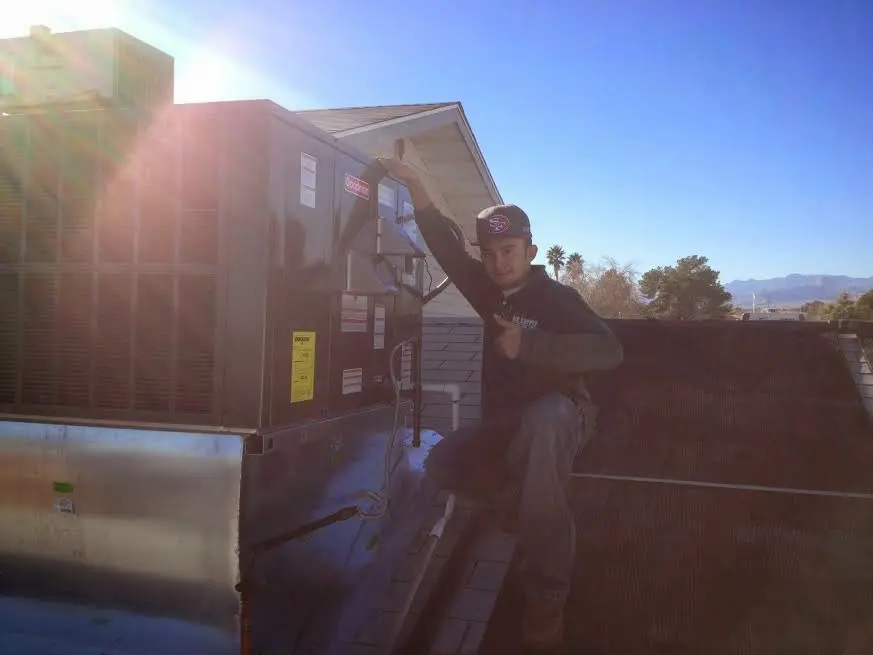 HVAC technician performing AC Tune-Up on a rooftop unit in Oak Hills
